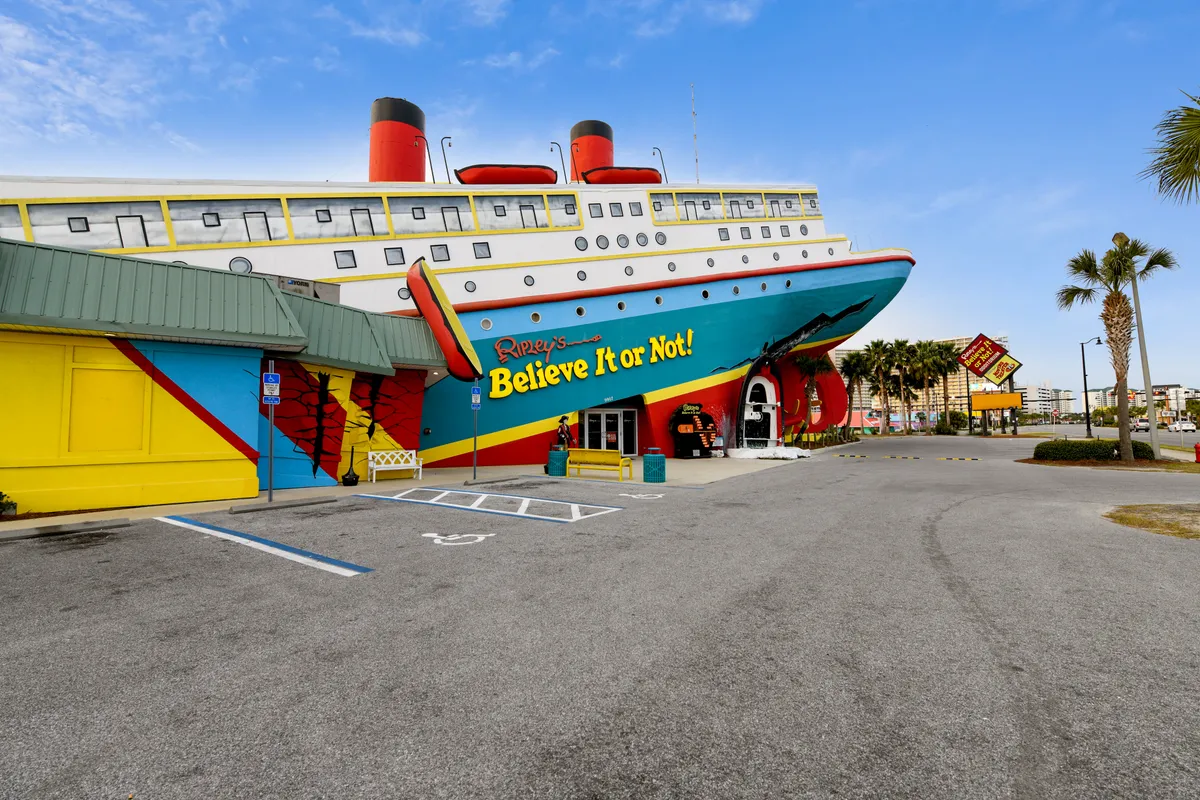 The image showcases the bold, colorful ship facade of Ripley's Believe It or Not! with bright building walls, palm trees, and accessible parking out front. The lively exterior hints at interactive exhibits and memorable experiences inside, inviting group outings to this local entertainment hotspot.